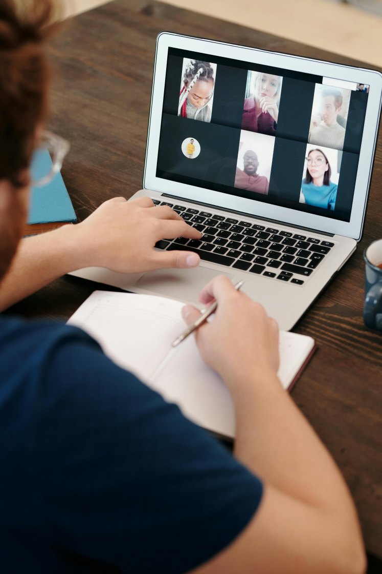 Person looking at laptop screen in remote team meeting